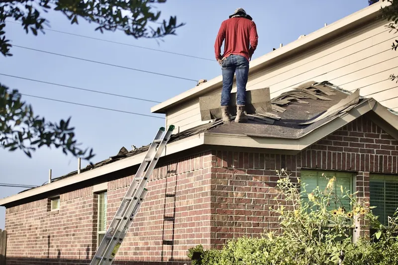 Professional roofer working on a residential roof in John Town